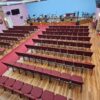 Stackable padded chairs arranged in a row inside a church or prayer hall