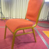 Side view of Auralis Series aluminum banquet chair with orange-red fabric upholstery