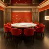 Red upholstered metal dining chairs around a large round table in a luxurious private restaurant room with golden accents and decorative wall art