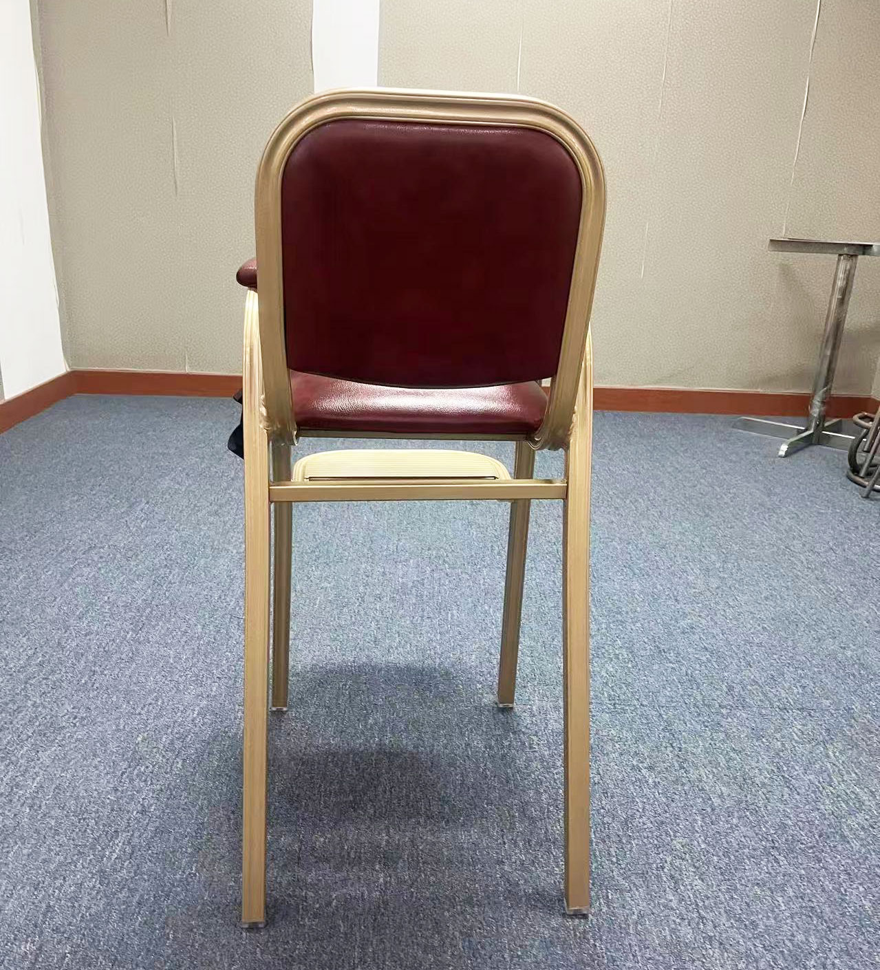 Rear view of hotel baby dining chair with golden frame and maroon upholstered backrest