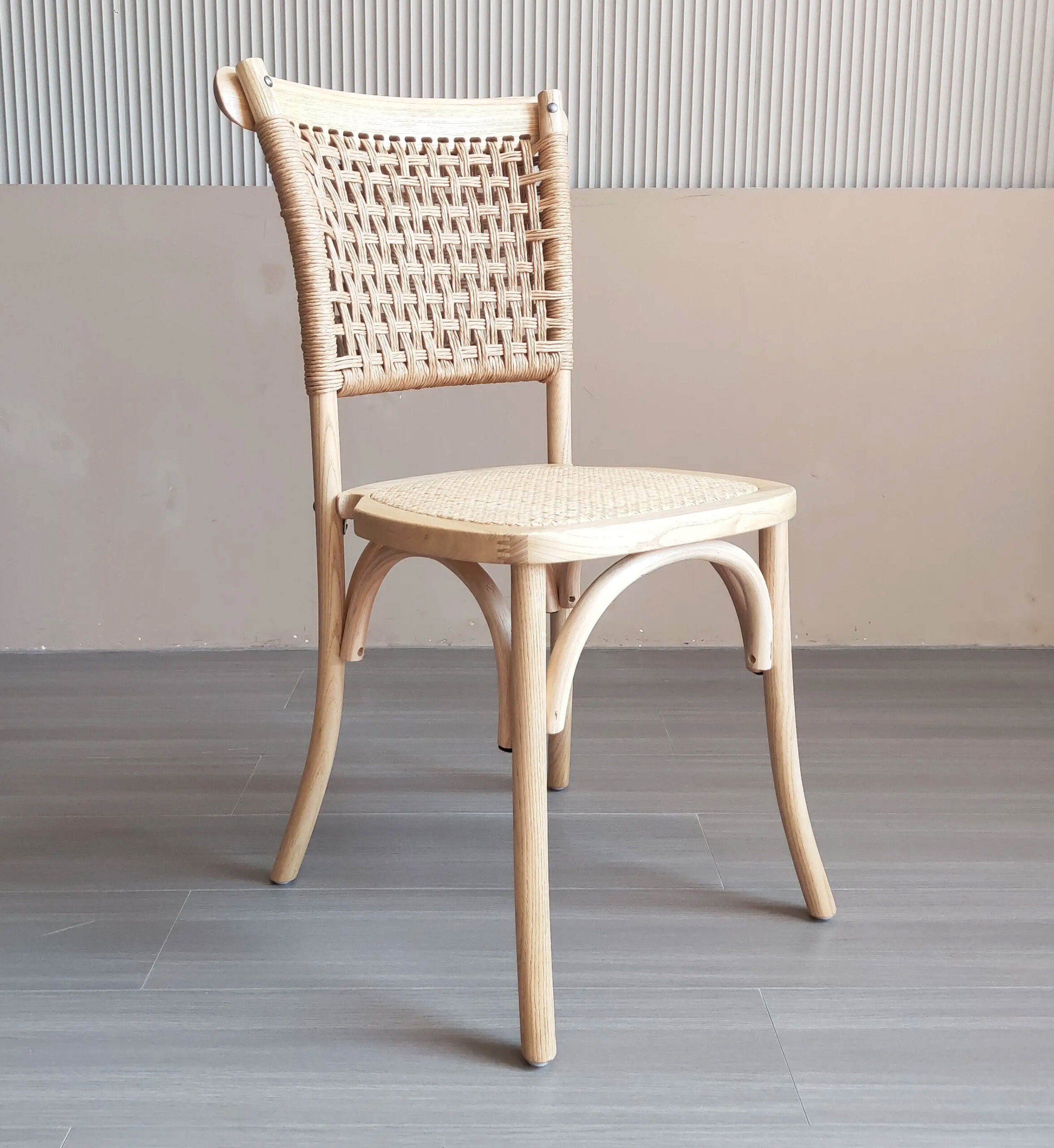 Angled view of loop-back dining chair with rope-woven backrest and natural rattan seat on beech wood frame