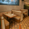Restaurant booth with upholstered seat and vertical wall paneling