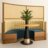 Teal restaurant booth with wooden table, flower vase, and ambient interior