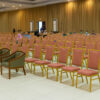 Red banquet chairs with patterned fabric and gold steel frames arranged in a hotel banquet hall