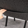 close up of church chair fabric book pocket showing storage function with hand demonstration on upholstered backrest
