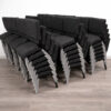 stacked fully upholstered church chairs in factory showing bulk production and space saving stacking design