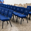 Blue upholstered church chairs with custom logo branding arranged in worship hall installation setup