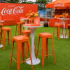 Custom logo Tolix bar stools used in a beverage brand promotional event with branded seating, cocktail tables and outdoor hospitality setup