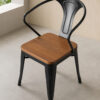 Commercial Tolix dining chair with arms featuring a walnut wood seat and black powder-coated steel frame