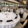 Curved Back Aluminum Dining Chairs with light oak wood grain finish installed in a commercial hotel and restaurant dining project with round banquet tables.