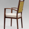 Rear angle view of Harbor Arm aluminum dining chair with front casters, wood grain finish, upholstered seat and patterned backrest for hospitality and senior living spaces.