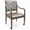 Heritage Aluminum Arm Dining Chair with light oak wood grain finish, floral upholstered back, taupe seat cushion, and front leg casters, shown as a custom color option for senior living and healthcare seating.