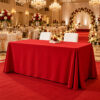 Red rectangular polyester tablecloth displayed in an elegant hotel banquet and event dining setup